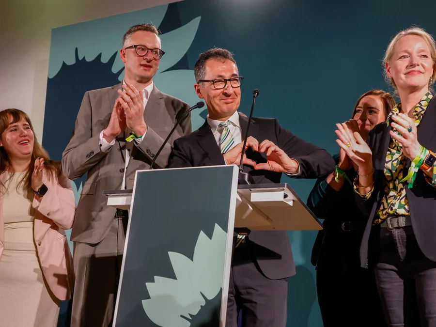 Cem Özdemir freut sich und formt mit seinen Händen ein Herz.