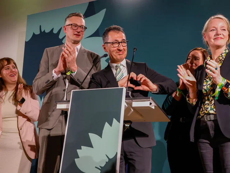 Cem Özdemir freut sich und formt mit seinen Händen ein Herz.