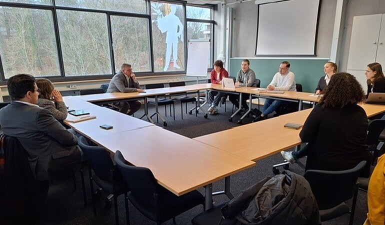 Die Teilnehmer sitzen am Tisch, um sich auszutauschen.