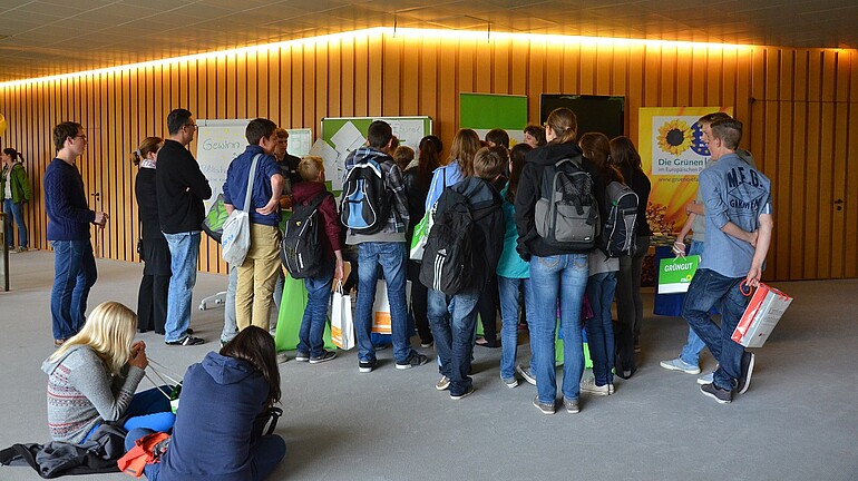 Viele Jugendliche stehen an einem Stand