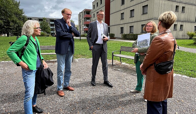 Menschen stehen draußen im Kreis 